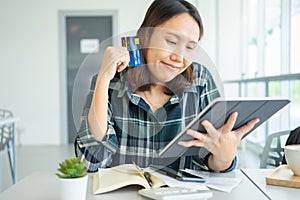 Confused portraitÃÂ young woman holding credit cards having problem online payment with credit card making rejected unsecure online